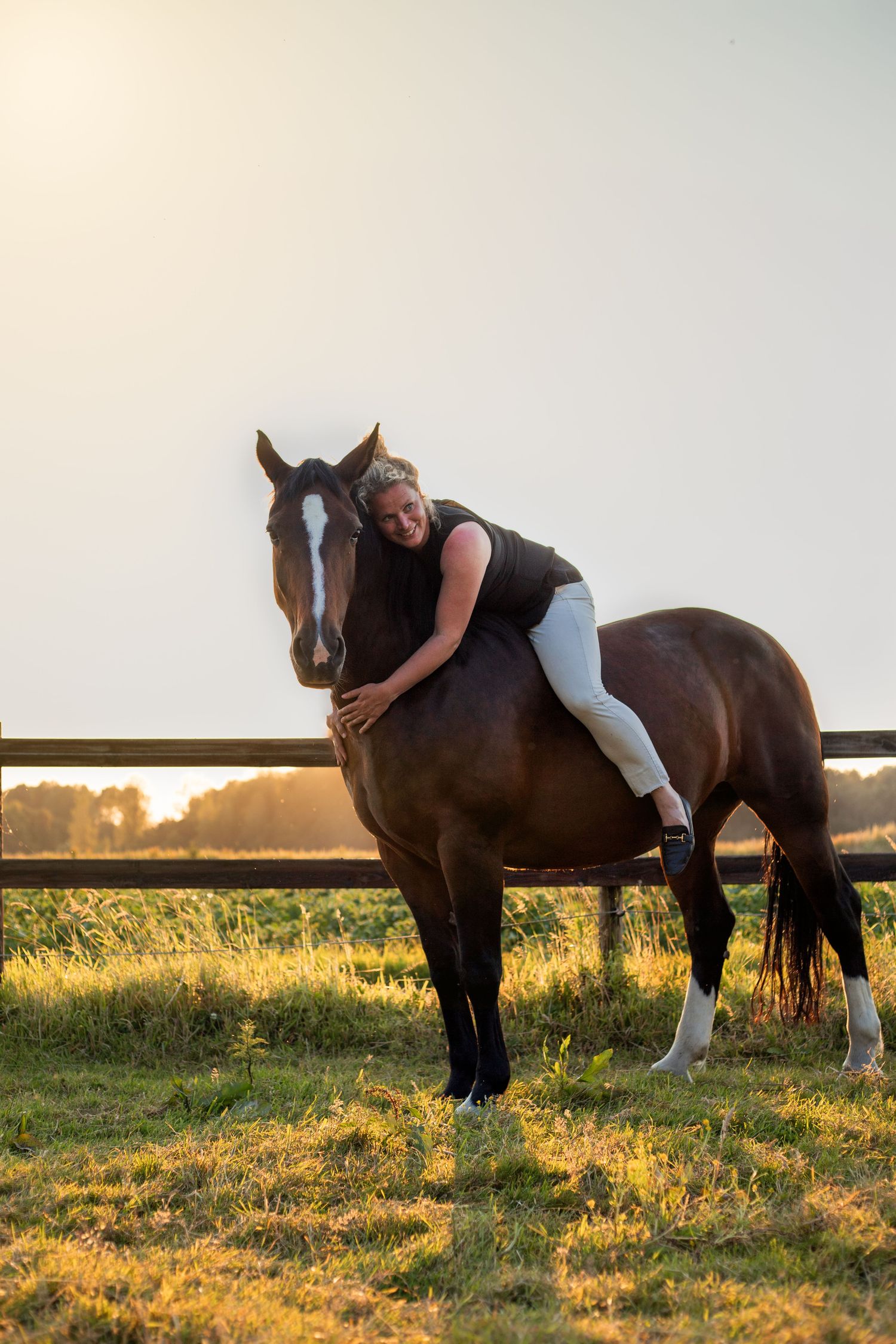 vrouw ligt op de rug van een paard