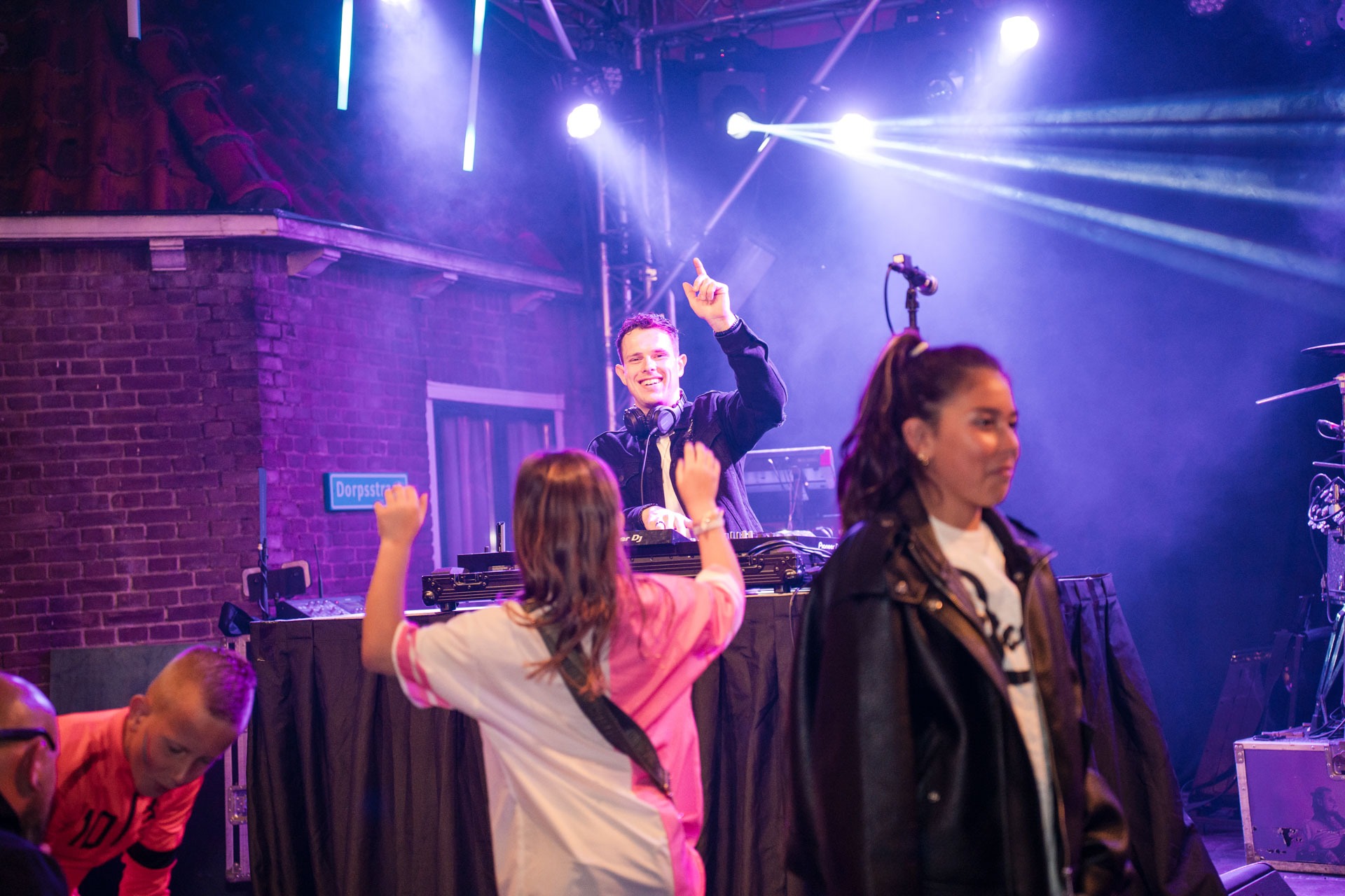DJ Lancer wijst enthousiast naar het publiek tijdens zijn avondset, sfeerbeeld gemaakt door eventfotograaf