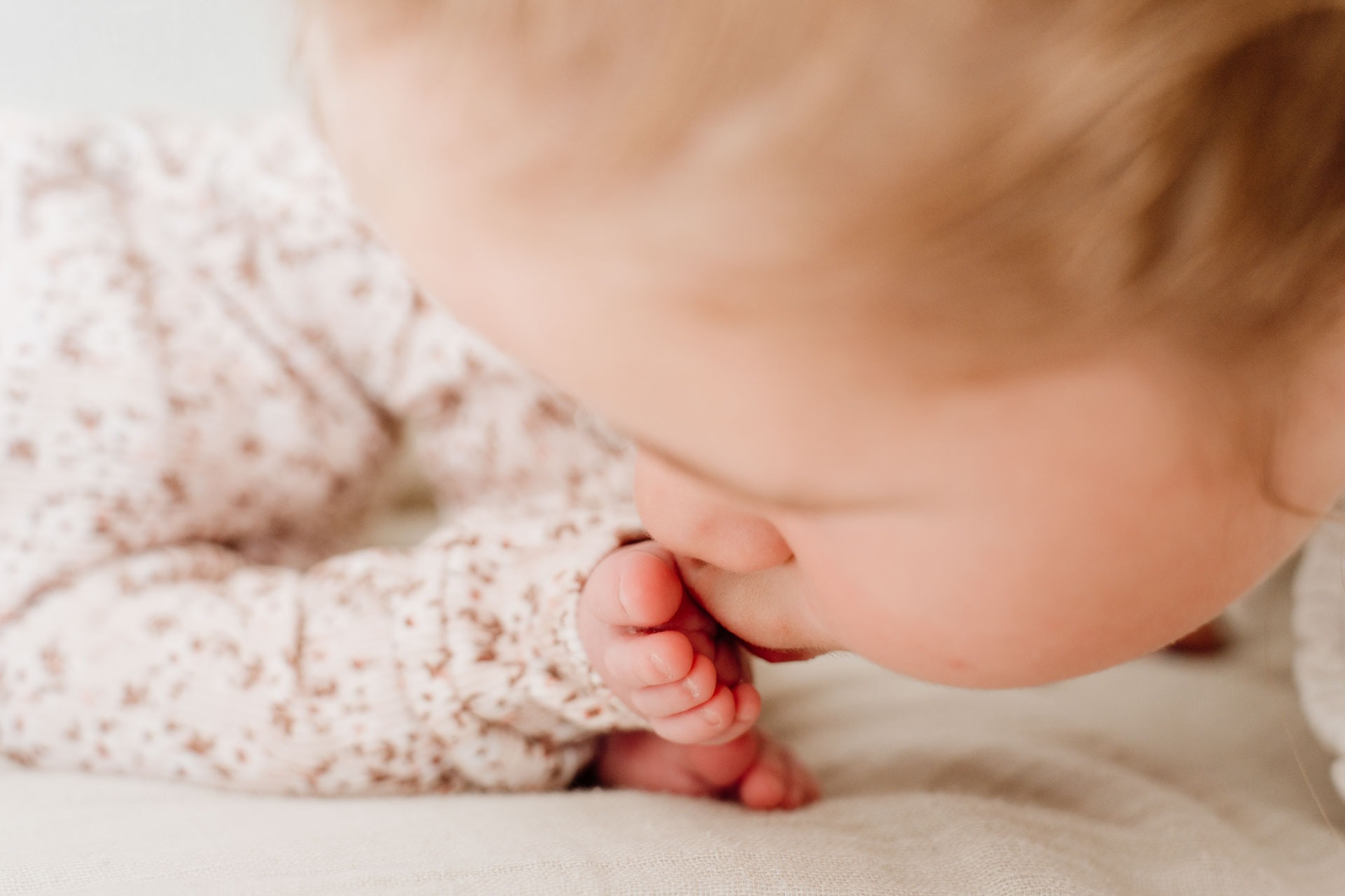Slapende newborn Yara-Nove van dichtbij, met haar kleine handjes en lippen in beeld tijdens de newborn fotoshoot thuis in Zuidland.